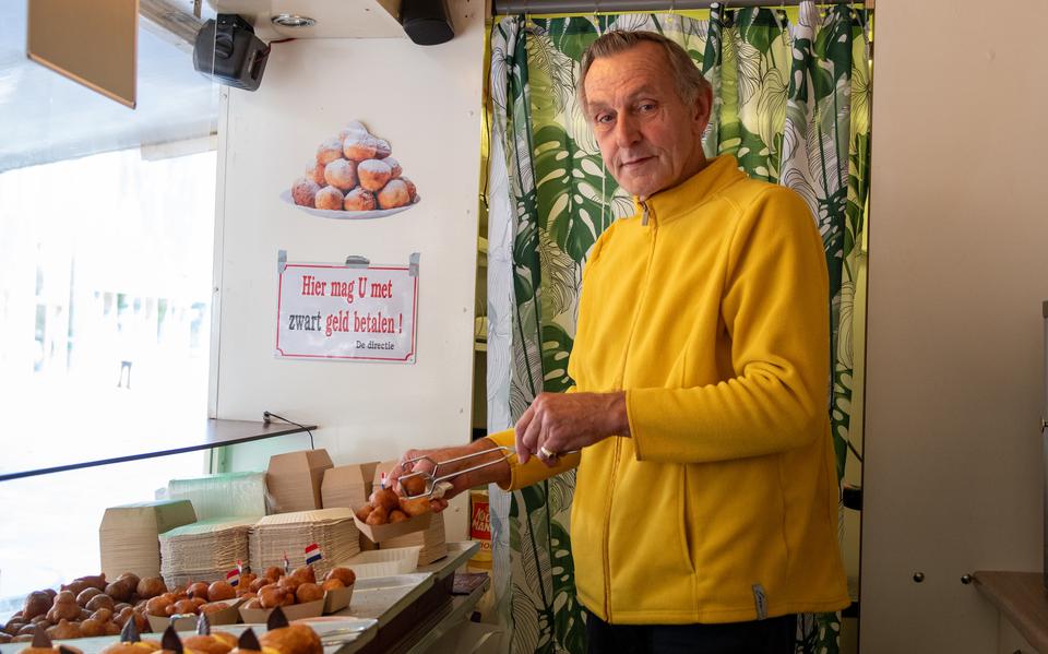 Henk Olijve in zijn kraam op het Raadhuisplein in Emmen. Hij verkoopt er onder meer mini-oliebollen, speciaal voor kinderen.