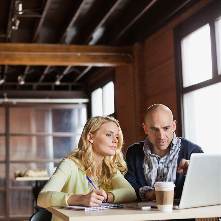 Entrepreneurs working on laptop in creative office space