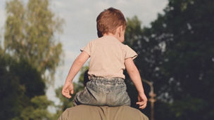 child on father shoulders