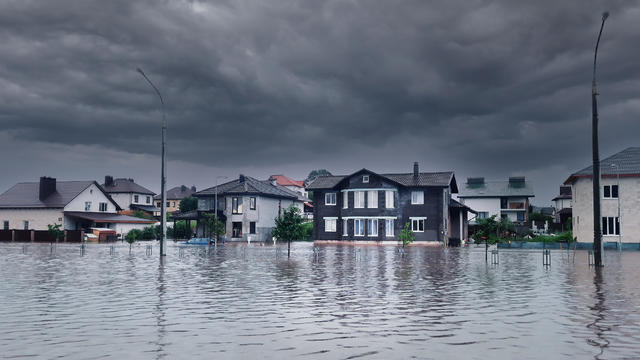 Extreme heavy rain storm weather. Flooded streets of the neighborhood. A flooded road junction with a drowned house. Heavy rains from tropical storm caused many flooded areas. Rains caused many floods 