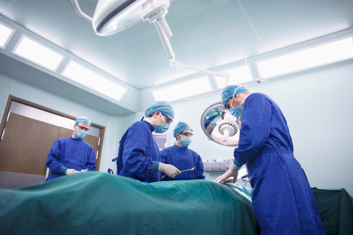 Operating room staff perform a surgery. 