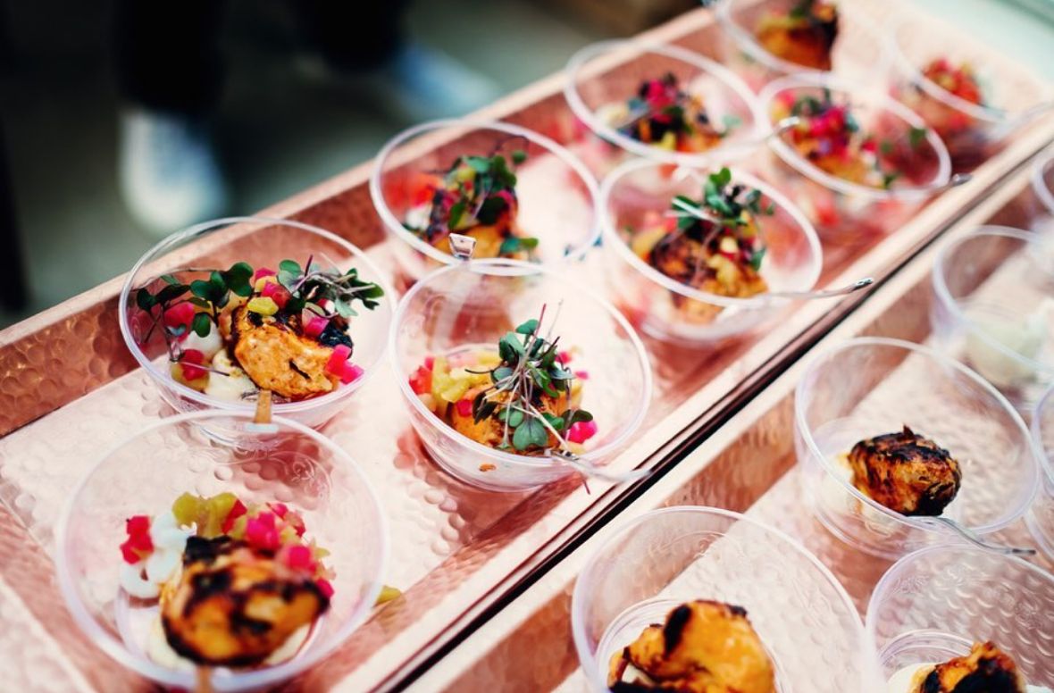 A selection of dishes in small cups setup on serving trays 