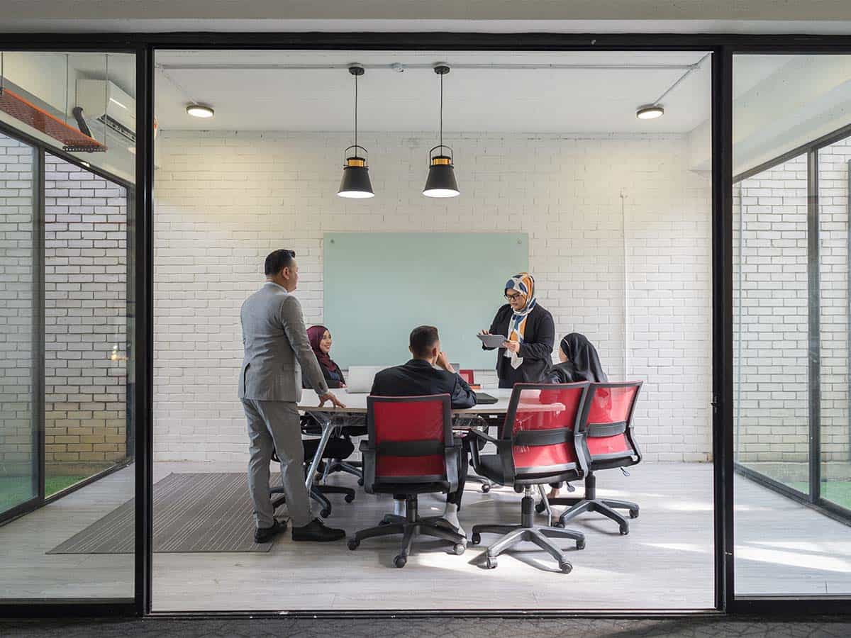 cinco pessoas em reunião na sala de conferências