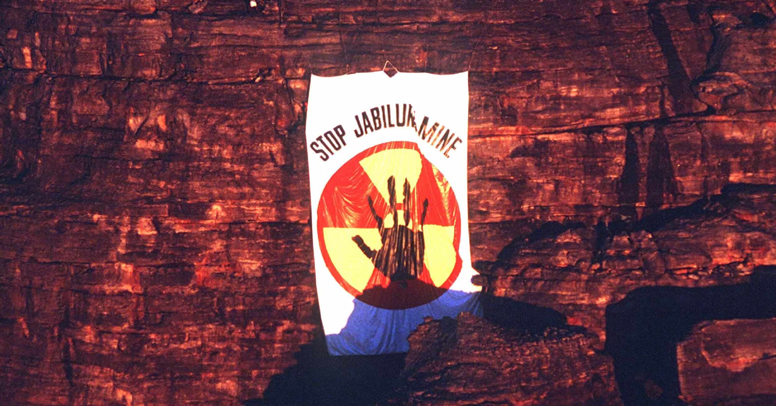 Stop Jabiluka Mine banner hanging on cliff rock face