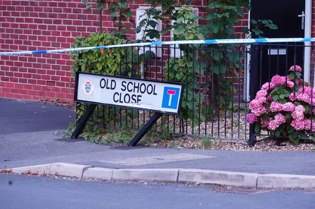 Police tape beside road sign reading Old School Close