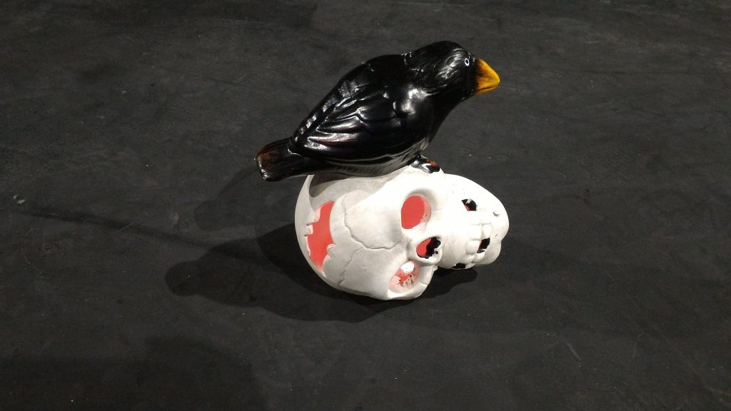 Skull prop with a plastic crow on top