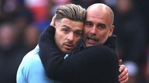 Jack Grealish (left) receives a hug from Manchester City manager Pep Guardiola