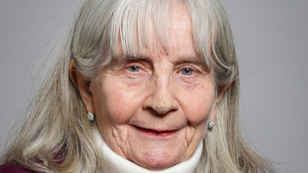 A woman in a white turtleneck smiling at the camera