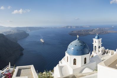 Early morning view in Santorini of the Imerovigli church sitting on top of the volcanic caldera. Santorini in Greece is one of the most famous travel destination in the World with numerous cruise ships anchoring in the bay below. The architecture is also famous for the duotone colors of the white painted buildings and light blue details.