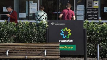 People wait outside a Services Australia outlet