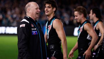 Ken Hinkley, coach of the Power, exchanges words with Hawthorn players.