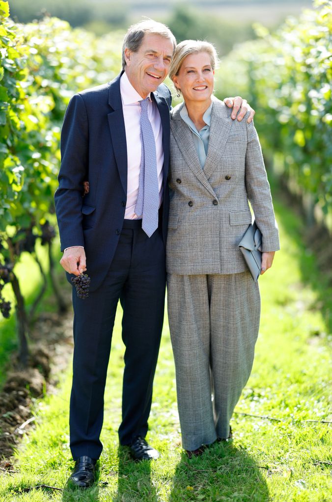 Sophie in grey plaid suit with Patrick McGrath in vineyard