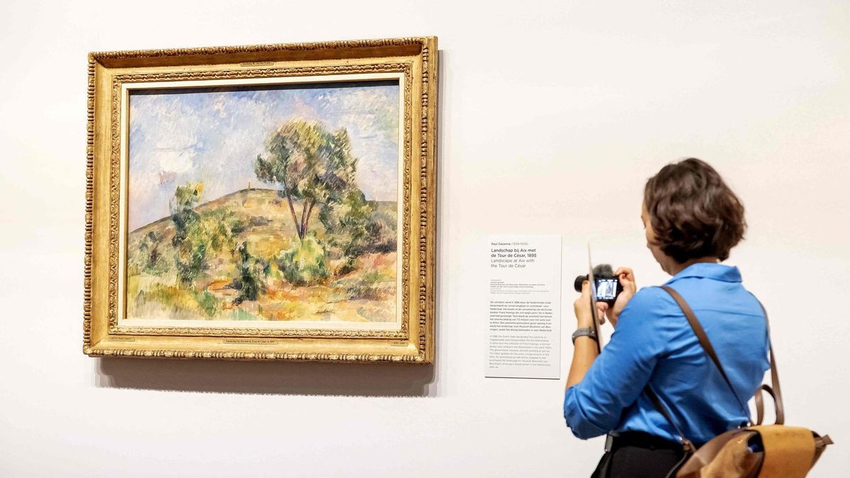 Eine Besucherin der Ausstellung fotografiert ein Gemälde des französischen Malers Paul Cézanne. 