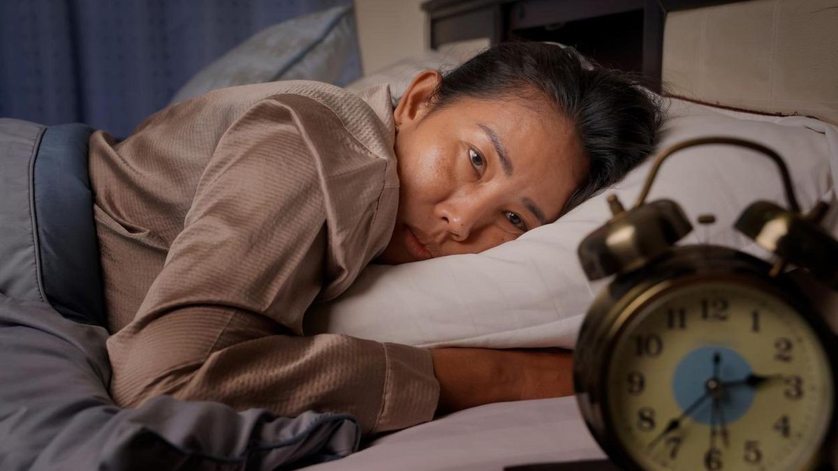 Eine Frau liegt im Bett und kann nicht schlafen: Die Zeitumstellung macht vielen Menschen zu schaffen.