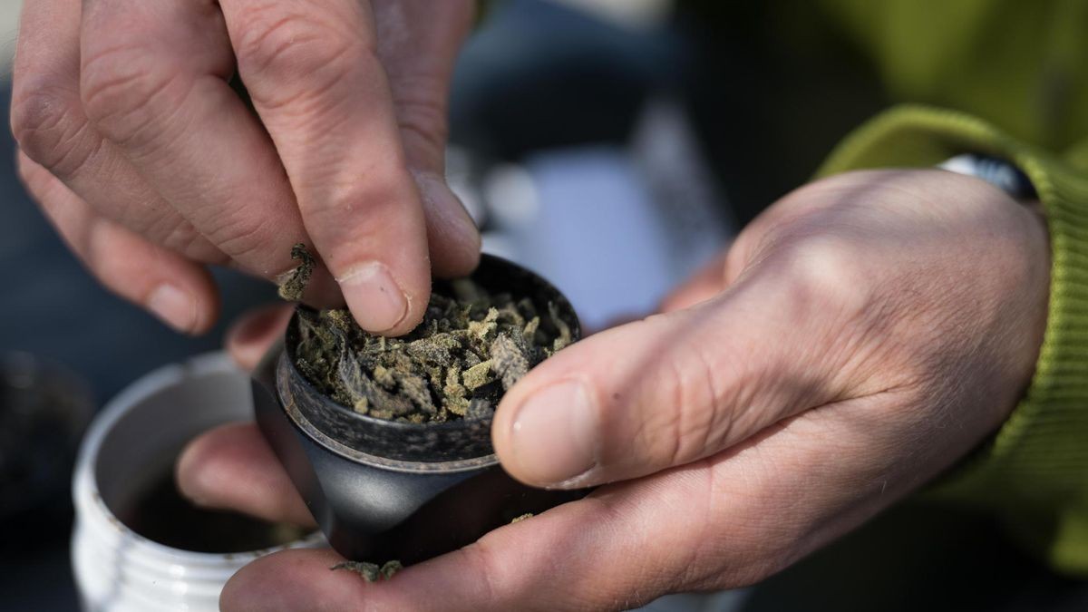 Ein Mann mit einem Grinder für Cannabis.