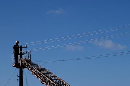 Ukrainekrieg: Sergij Buganov, a worker of electricity company Khersonoblenergo, repairs the power cord of a pylon amid Russia's invasion of Ukraine, in Pravdyne, Kherson region, Ukraine, February 23, 2023. REUTERS/Lisi Niesner