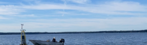 A small boat floats beside a buoy, named David's Buoy, on Lake Mendota.