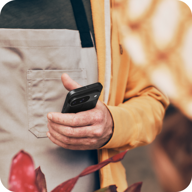 A man using his Google Pixel 9 phone at his flower shop.