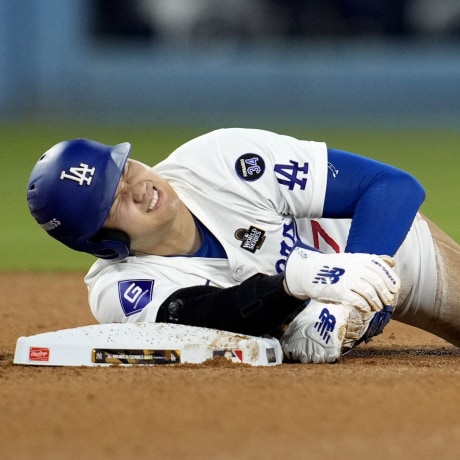 Los Angeles Dodgers' Shohei Ohtani holds his arm after being injured while trying to steal second base during the seventh inning in Game 2 of the World Series against the New York Yankees on Saturday, Oct. 26, 2024, in Los Angeles. 