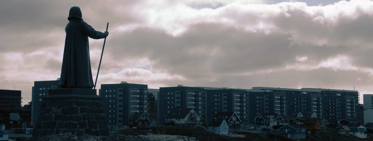 Statue af Hans Egede kigger ud over Nuuk i aftenskumringen. Foto fra 2010