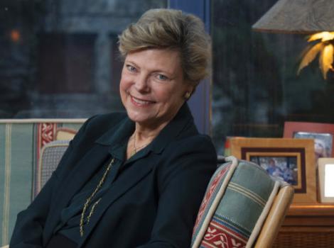 smiling woman seated in an upholstered chair