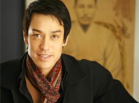 waist length photo of a young Asian man in a black sweater and patterned scarf