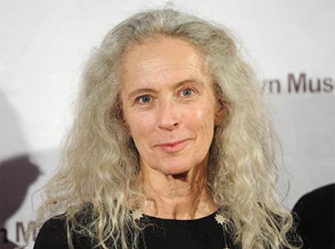 woman with long, curly gray hair in a black dress