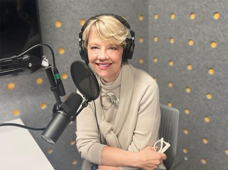 Woman seated in a podcast studio