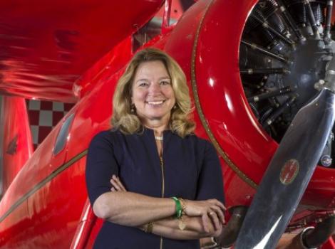 Woman in black standing in front of a red plane