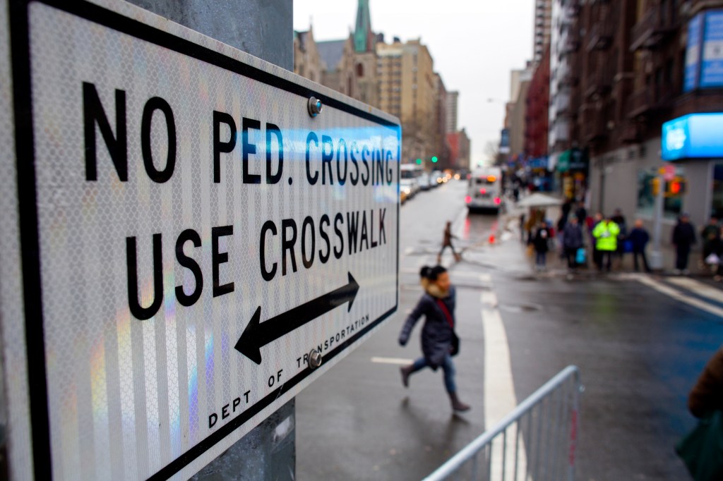 A person jaywalks in front of a "No Pedestrian Crossing" sign at the intersection of W. 96th Street and Broadway on Jan. 27, 2014.