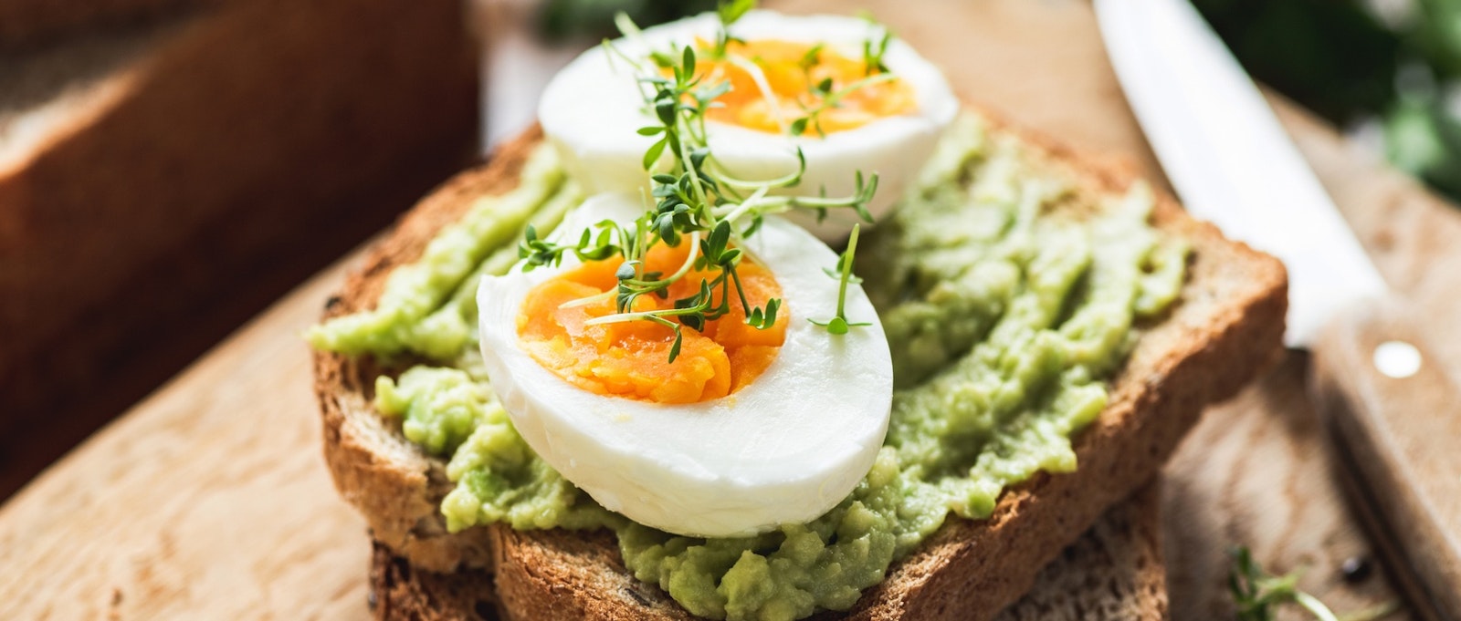 Healthy Breakfast Toast With Avocado, Boiled Egg On Wooden Cutting Board