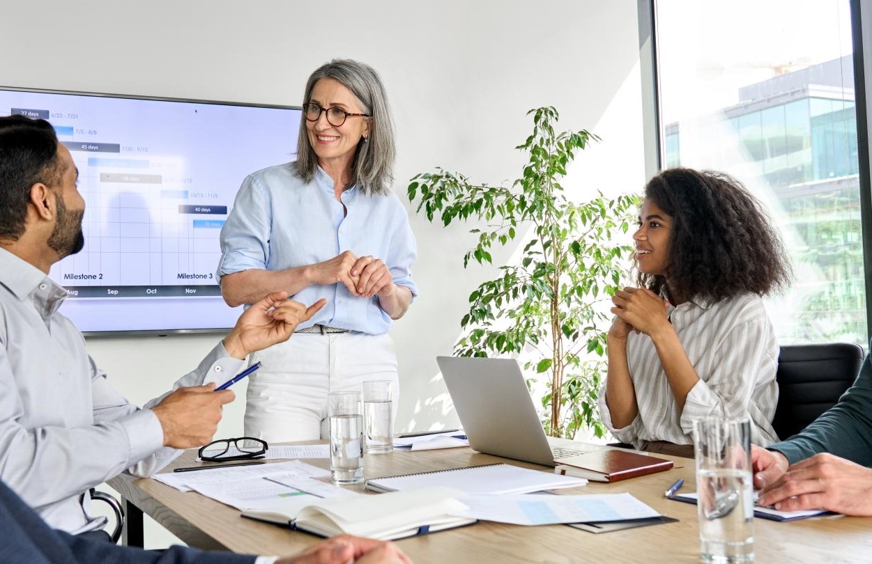 Team of 5 people having a business meeting discussing results