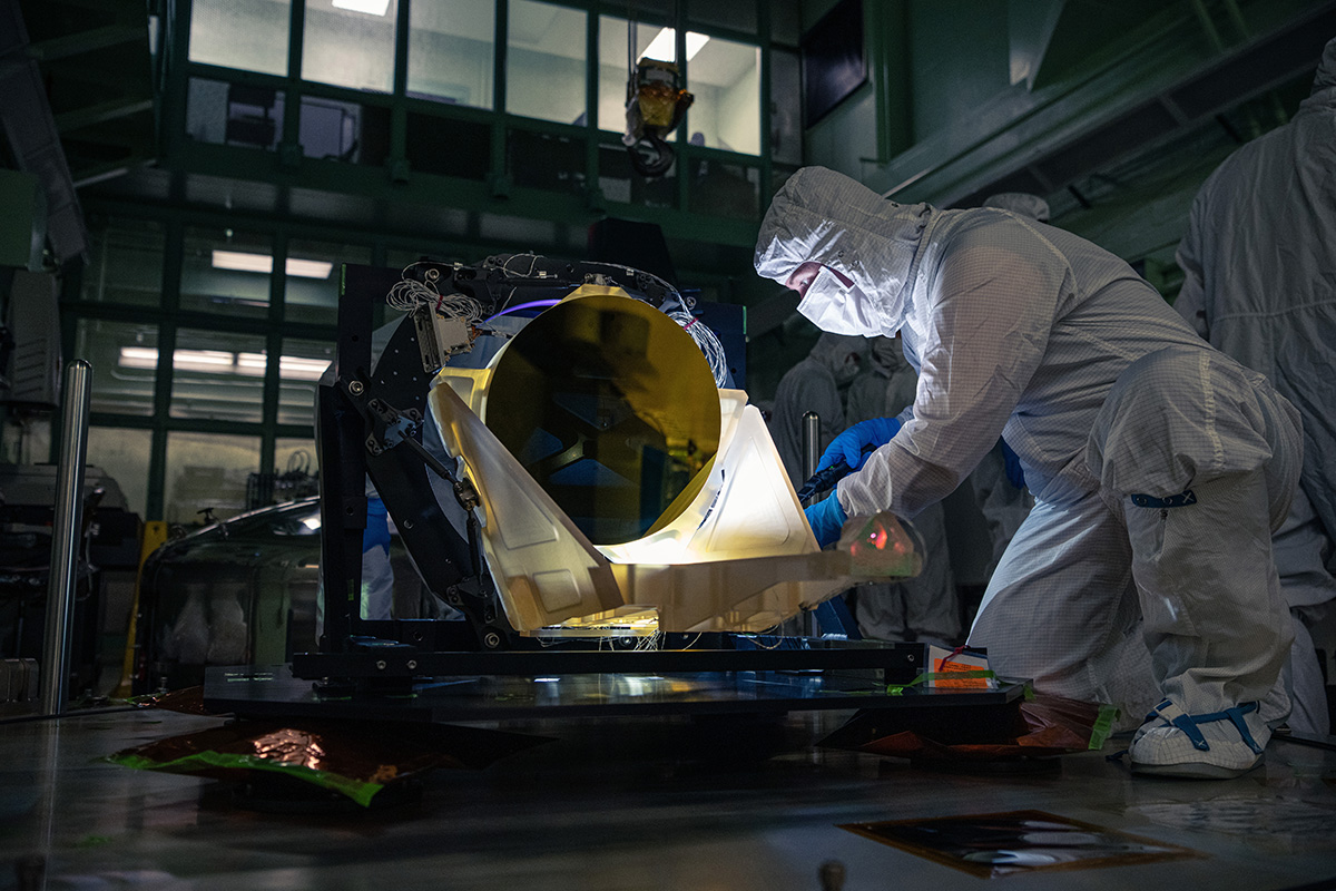 A technician inspects a prototype LISA telescope.