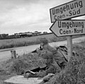 Lance Corporals A Burton and L Barnett of 6th Airborne Division guarding a road junction near Ranville, 7 June 1944. Horsa gliders can be seen behind.