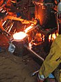 Students pouring iron from a hand built coupla at the Wayne State University foundry in Detroit, Michigan