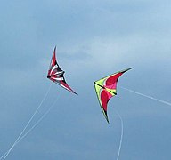 Two dual line stunt kites flying in a formation