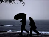 A CORUÑA, 09/10/2024.- Dos personas caminan este miércoles por el paseo marítimo de A Coruña, donde los efectos del antiguo huracán Kirk no se han hecho notar con intensidad, aunque sí han sido cerrados los parques y playas de la ciudad. La borrasca Kirk que atraviesa hacia el noreste de Europa se situará el miércoles sobre el noroeste peninsular acompañada de rachas de viento de hasta 120 km/h y precipitaciones en casi toda la Península, pudiendo ser copiosas, fuertes o persistentes en el Pirineo, área cantábrica, Sistema Central y Galicia. EFE/ Cabalar