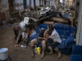 Tania hugs her brother-in-law Baruc after rescuing some of their belongings from their flooded house after the floods in Paiporta, Valencia, Spain, Tuesday, Nov. 5, 2024. (AP Photo/Emilio Morenatti)