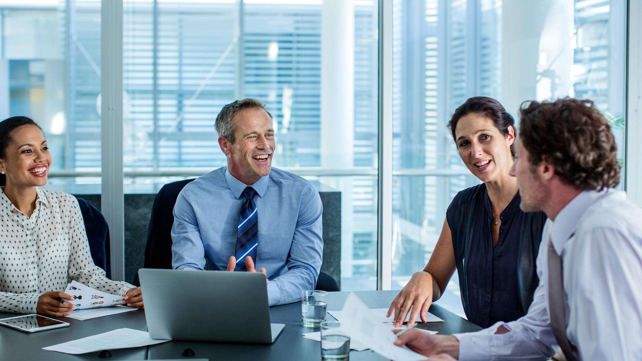 people smiling and chatting in office