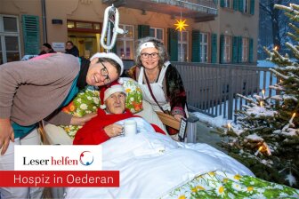 Wolfgang Auerswald ließ sich im Bett vor die Tür des Oederaner Hospizes fahren, um beim Weihnachtsmarkt dabei zu sein. Mit im Bild Sozialarbeiterin Kerstin Pönisch.