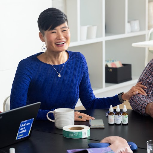 The owner and CEO of Asutra is seated with Asutra products by her side