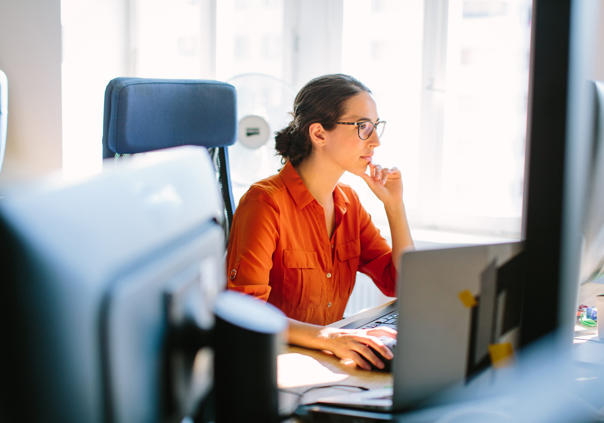 Shot of business woman sitting at her desk and working on desktop computer