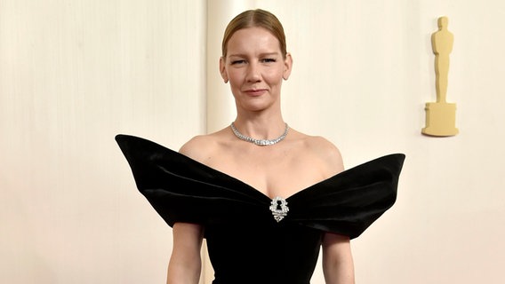 Schauspielerin Sandra Hüller bei der Verleihung der Oscar-Gala auf dem roten Teppich mit schwarzem Kleid © Richard Shotwell/Invision/AP/dpa +++ dpa-Bildfunk +++ Foto: Richard Shotwell