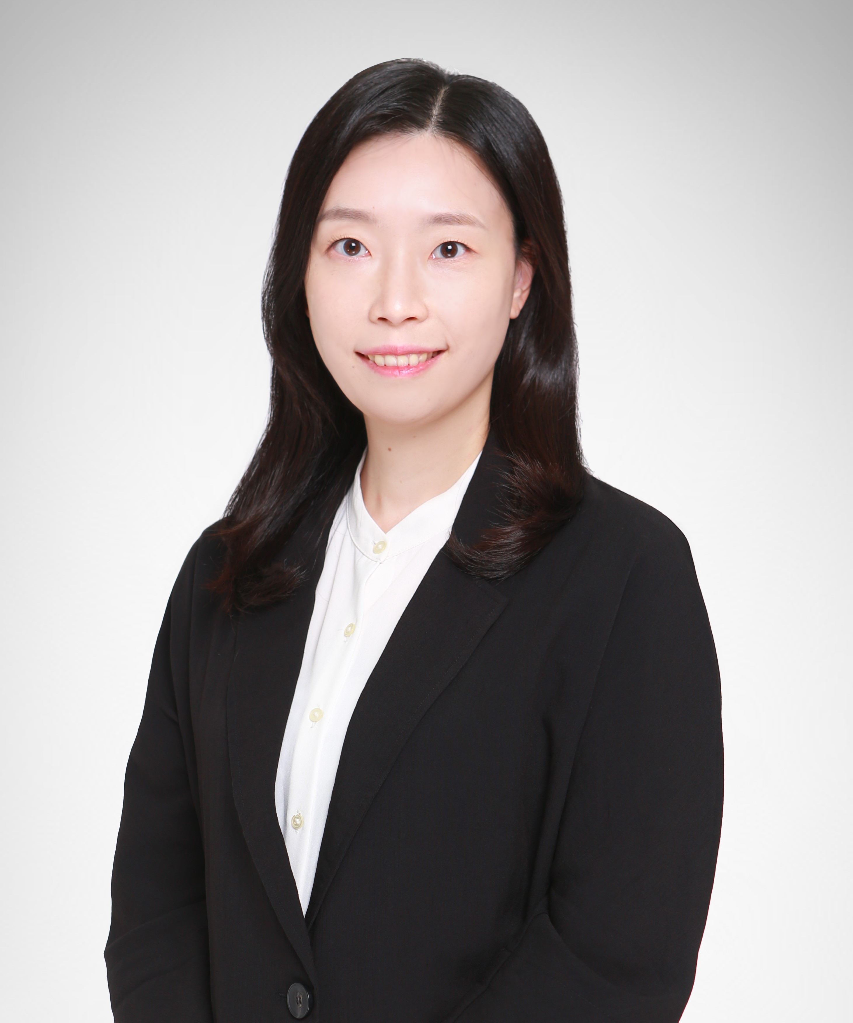 Photograph of a woman in a black blazer and white shirt