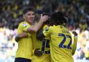 Mark Harris and Greg Leigh celebrate with Idris El Mizouni after his goal against Stoke City