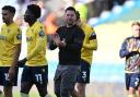 Oxford United head coach Des Buckingham applauds the home support at full-time against West Brom