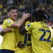 Mark Harris and Greg Leigh celebrate with Idris El Mizouni after his goal against Stoke City