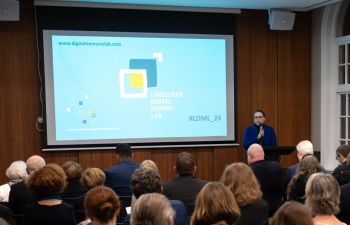 Prof Victoria Grace Richardson-Walden speaks at a podium in front of an audience at the launch of the Landecker Digital Memory Lab