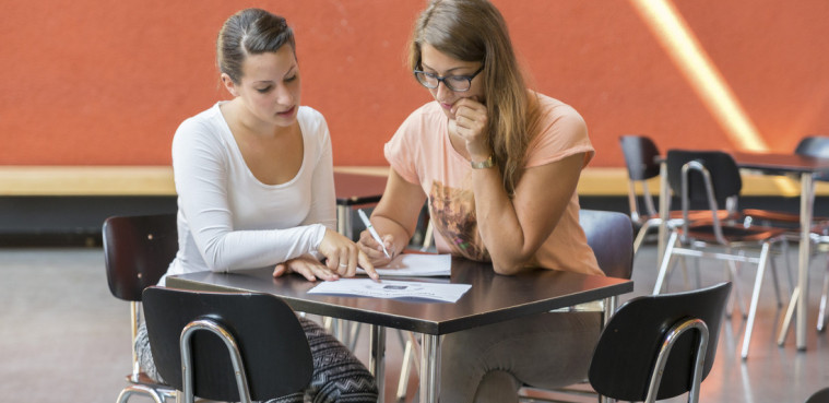 Two students sitting on a table