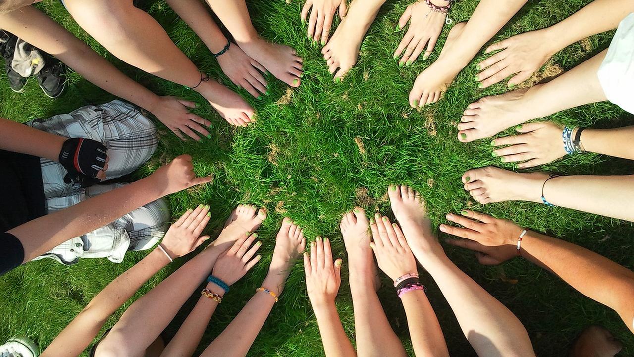 Hände und nackte Füße  in einem Kreis 